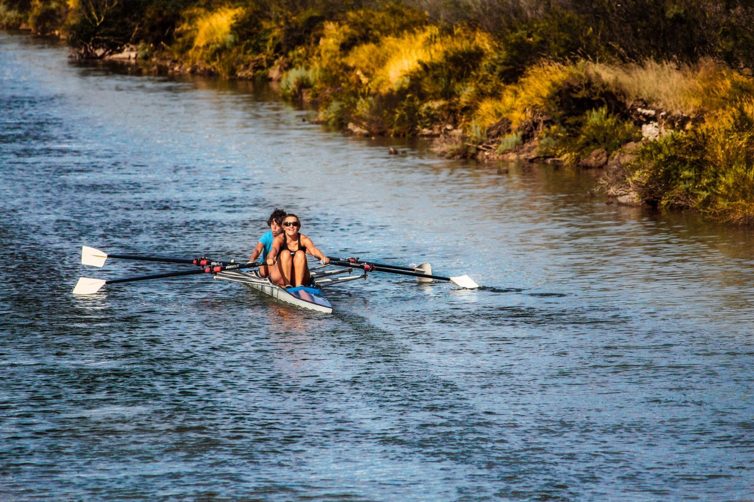 two people rowing a boat on a channel of water Town of Williamsport